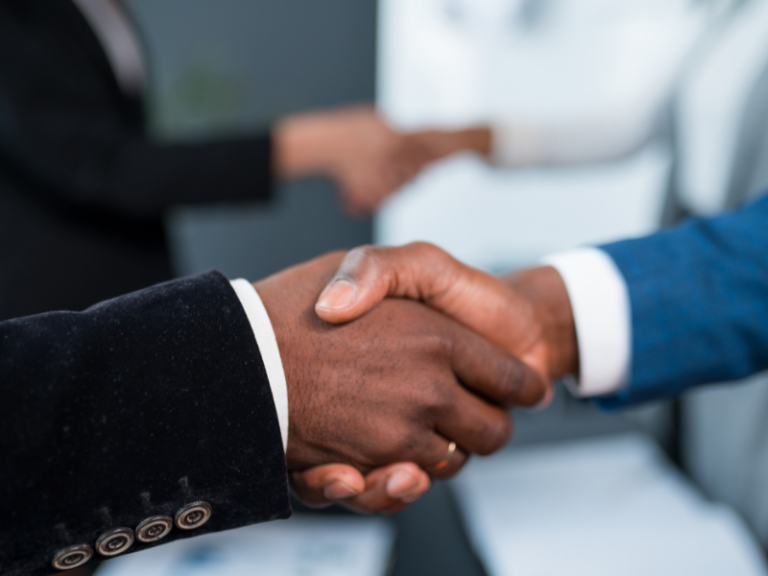 Adobe - A close-up of two black men shaking hands